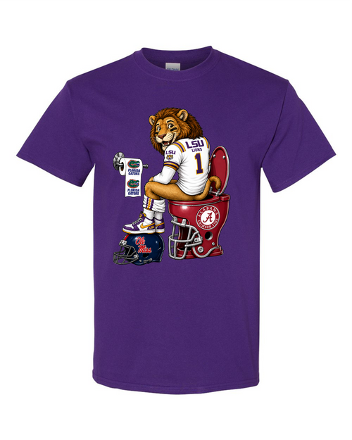 A purple short-sleeve crewneck t-shirt featuring a cartoon graphic of a lion wearing an LSU football jersey sitting on a red football helmet toilet, with a blue LSU helmet at its side.